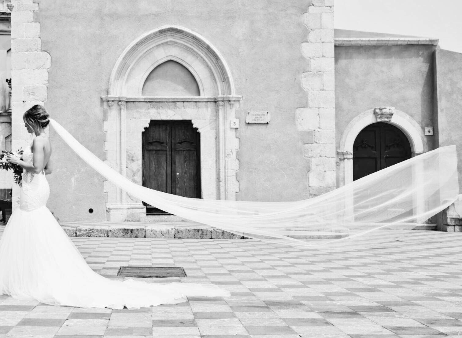 Bride with a long veil in a Taormina piazza